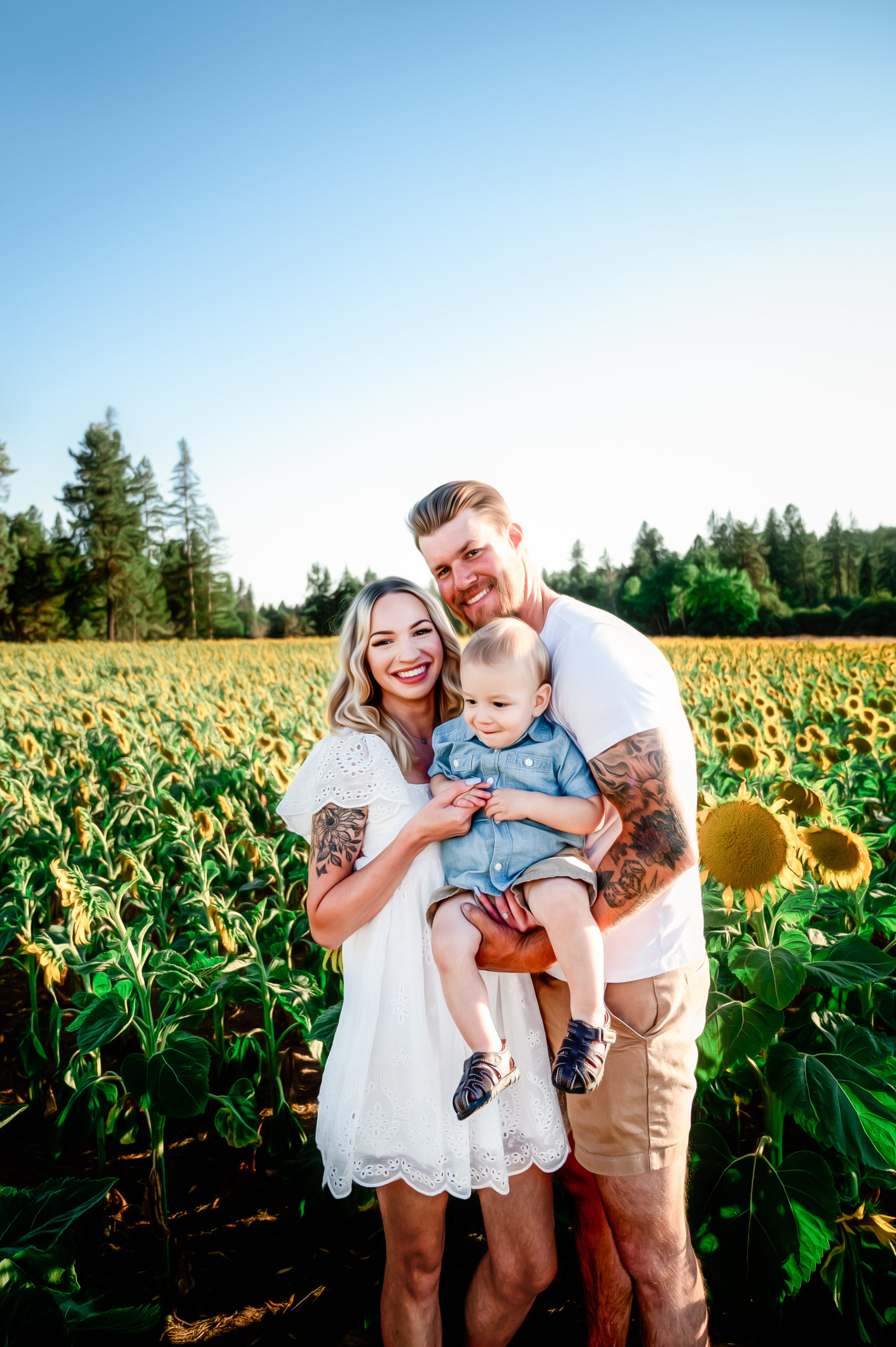 family of three standing in a field of sunflowers at Half Moon Blooms