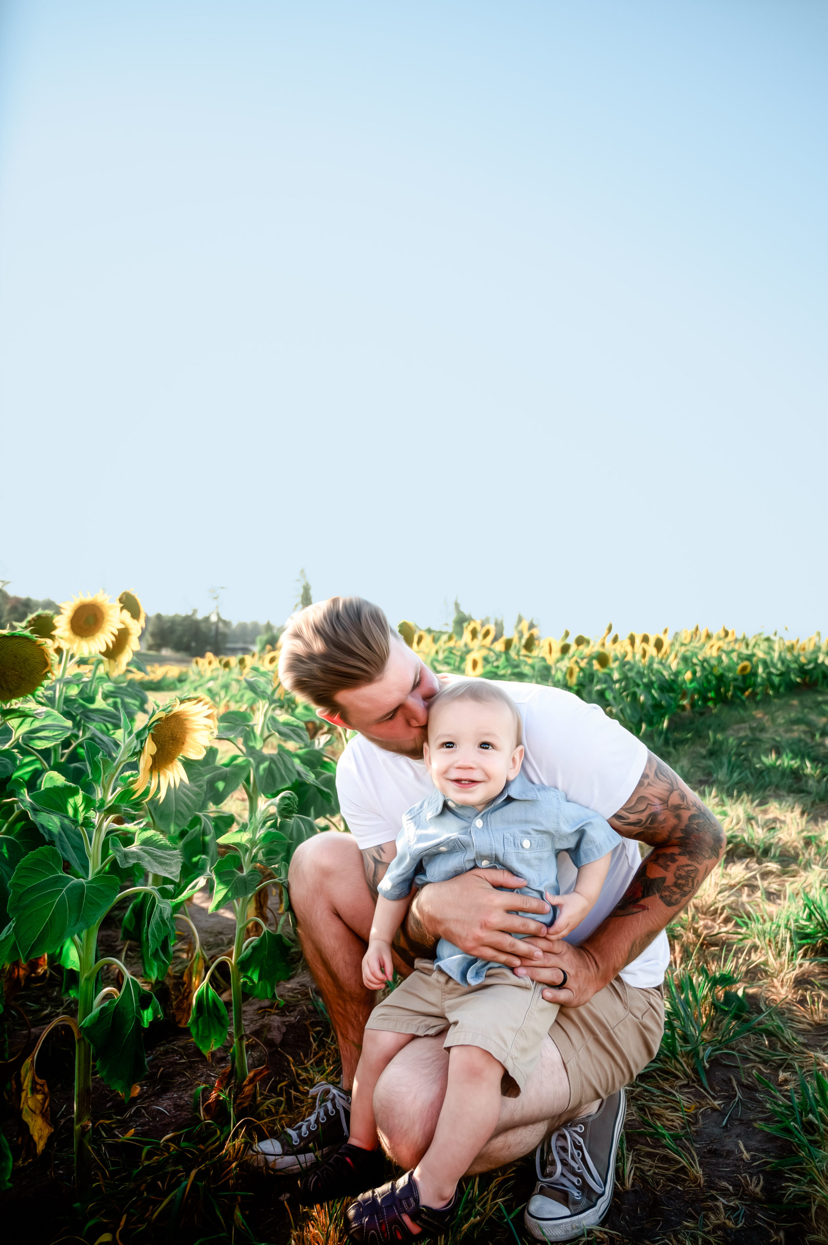 dad playing with his son in a sunflower field at Half Moon Blooms