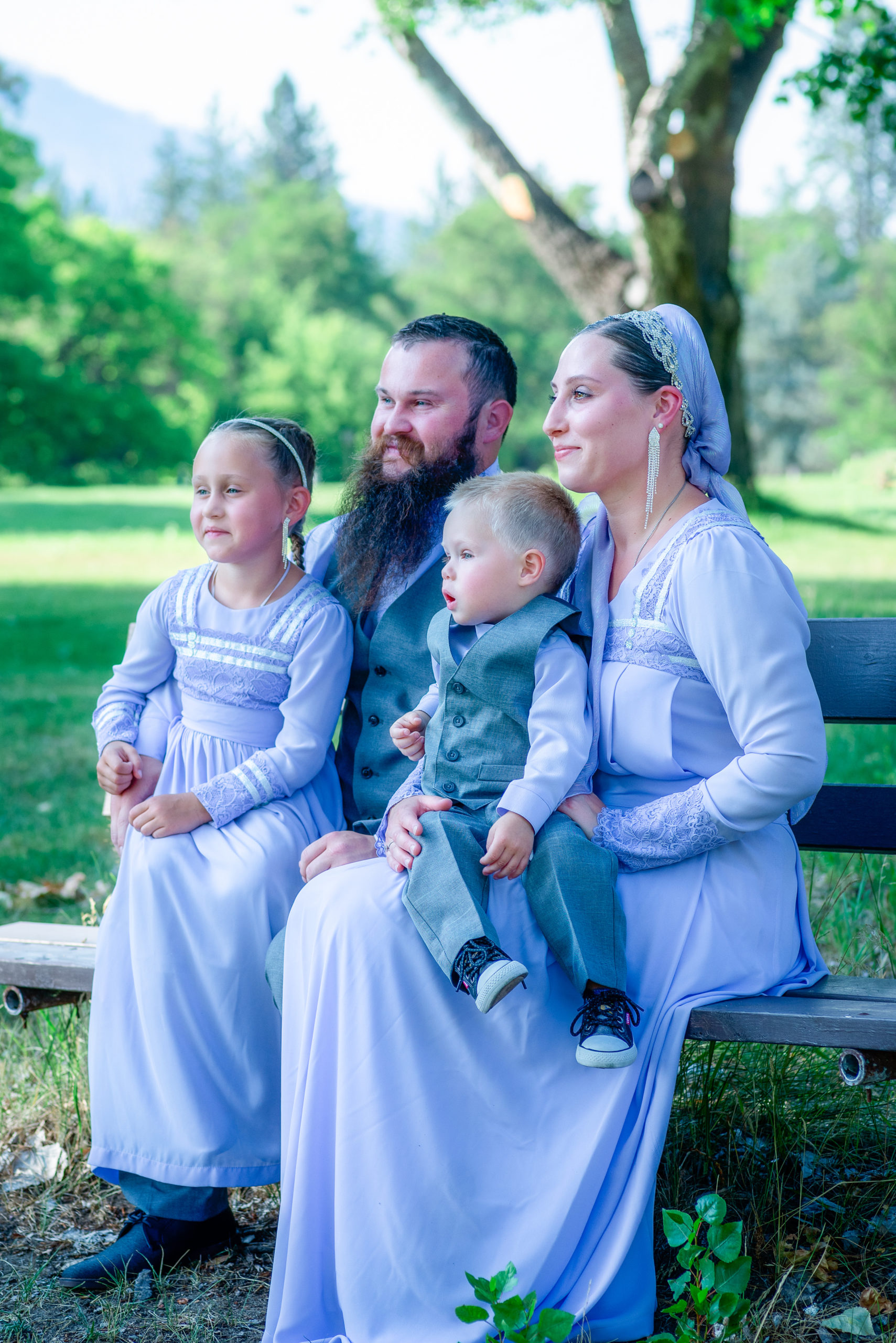 family of 4 sitting on a bench in a park spas in spokane