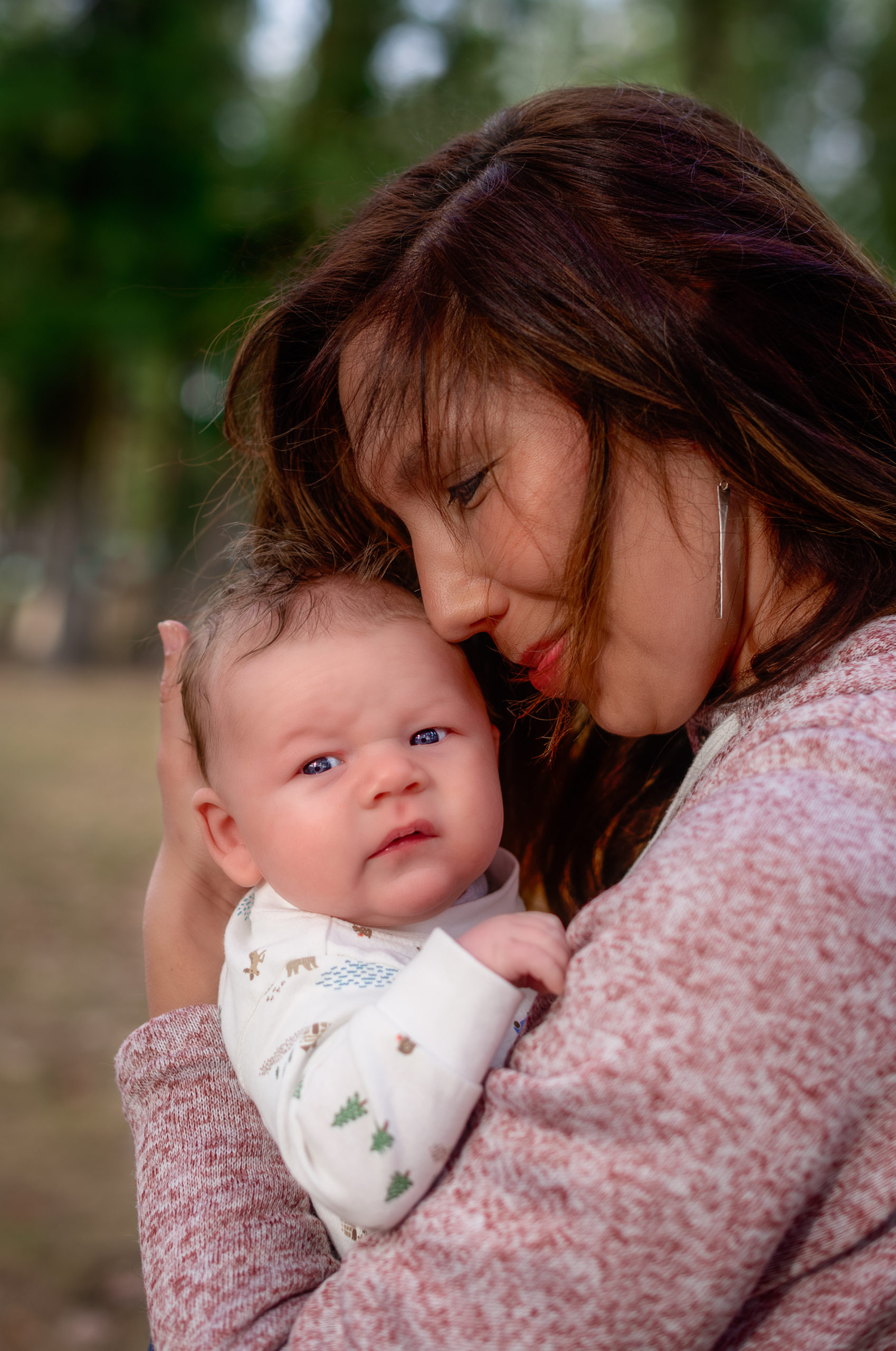 mom snuggling with her baby in a field Spokane Obstetrics and Gynecology