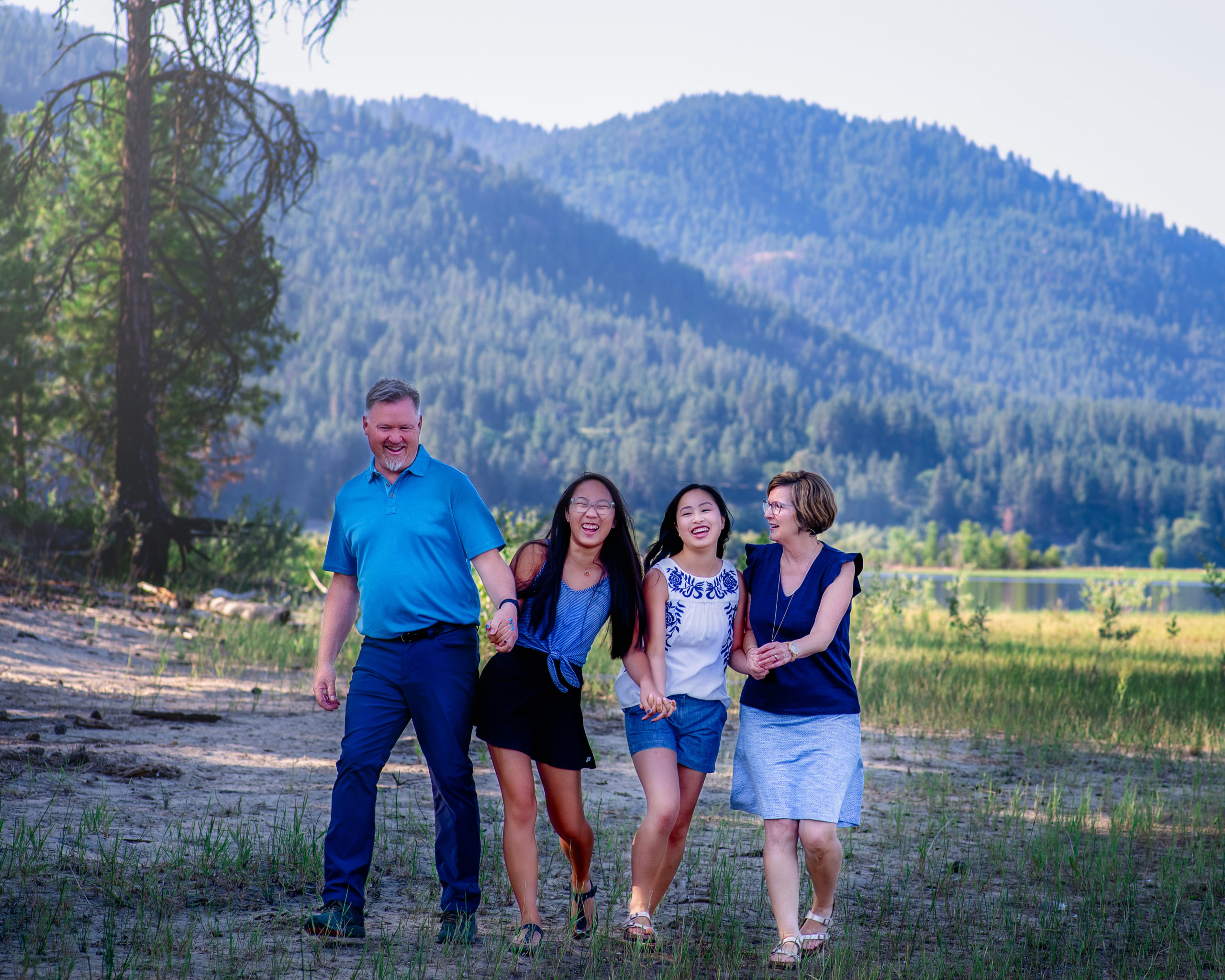 family of 4 laughing and walking together on a road spokane pediatric dentist